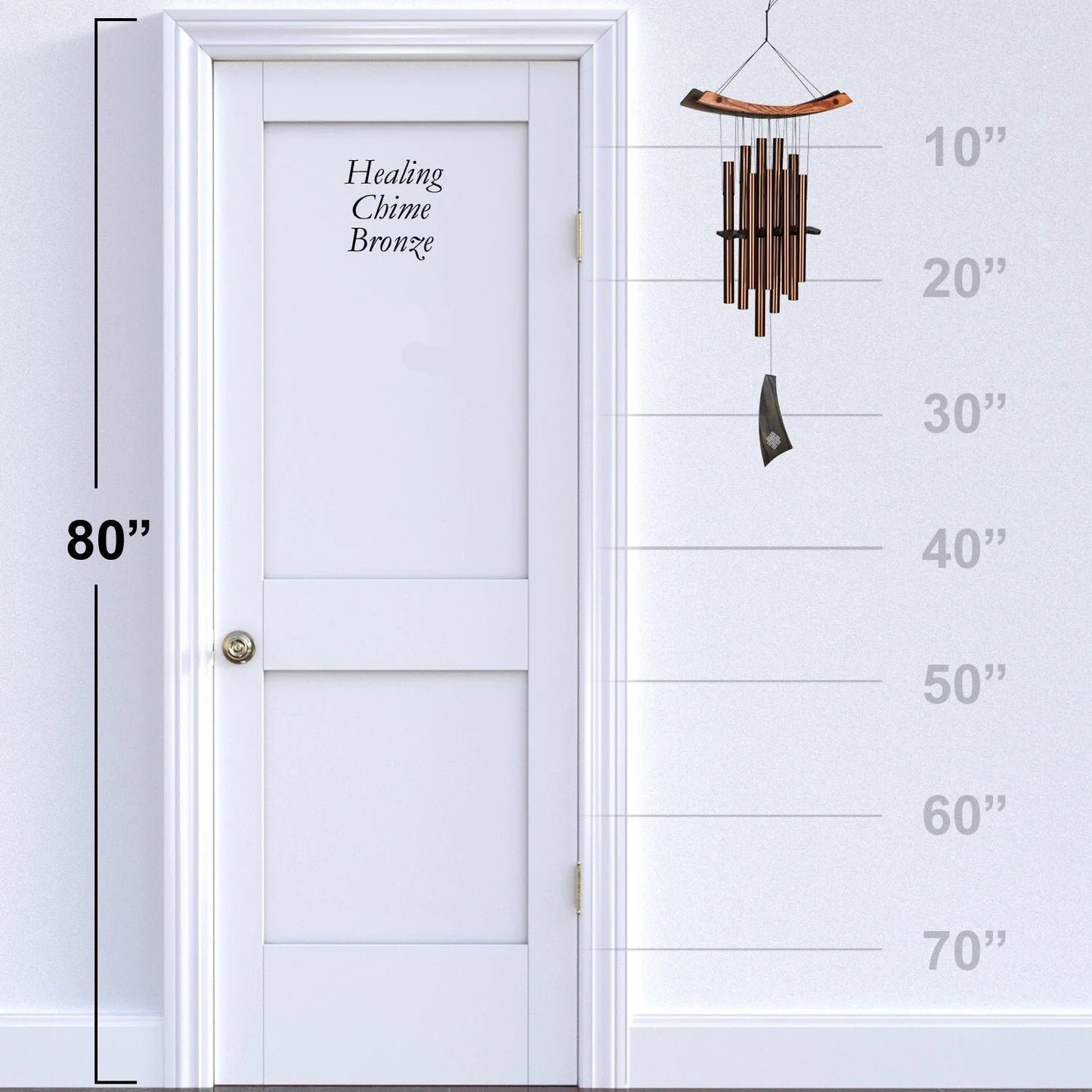 Woodstock Chimes wind chime next to a white door with height measurement scale.