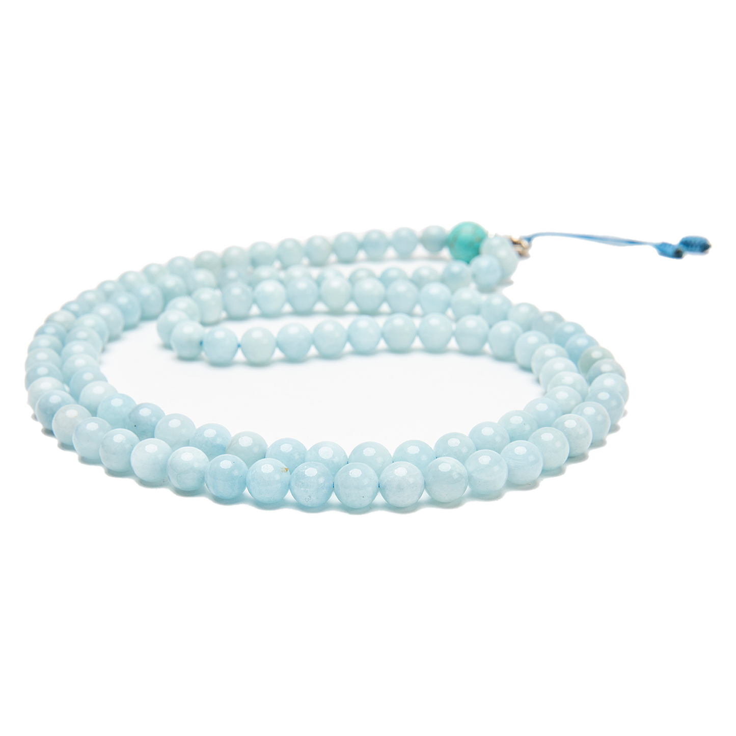 Close-up of the aquamarine beads of the mala against a solid white backdrop.