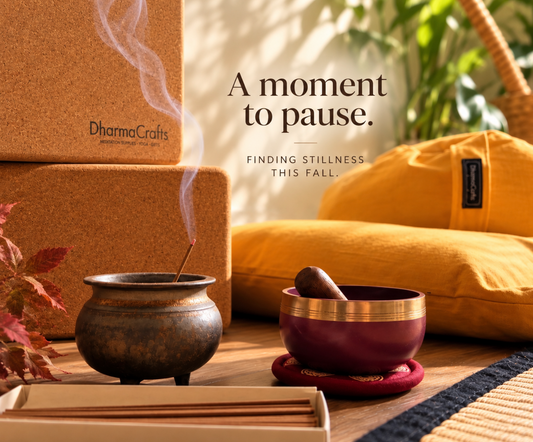 incense, sound bowl, zafu and zabuton mediation cushions, yoga blocks with a plant ready for a meditation session in a warm room
