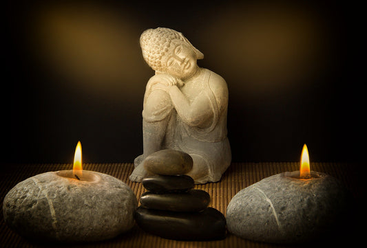 Seated Buddha with candle rocks and zen stones