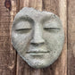 Concrete face sculpture on a wooden background