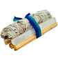 Two bundles of sage wrapped in white cloth with blue ribbons on a white background