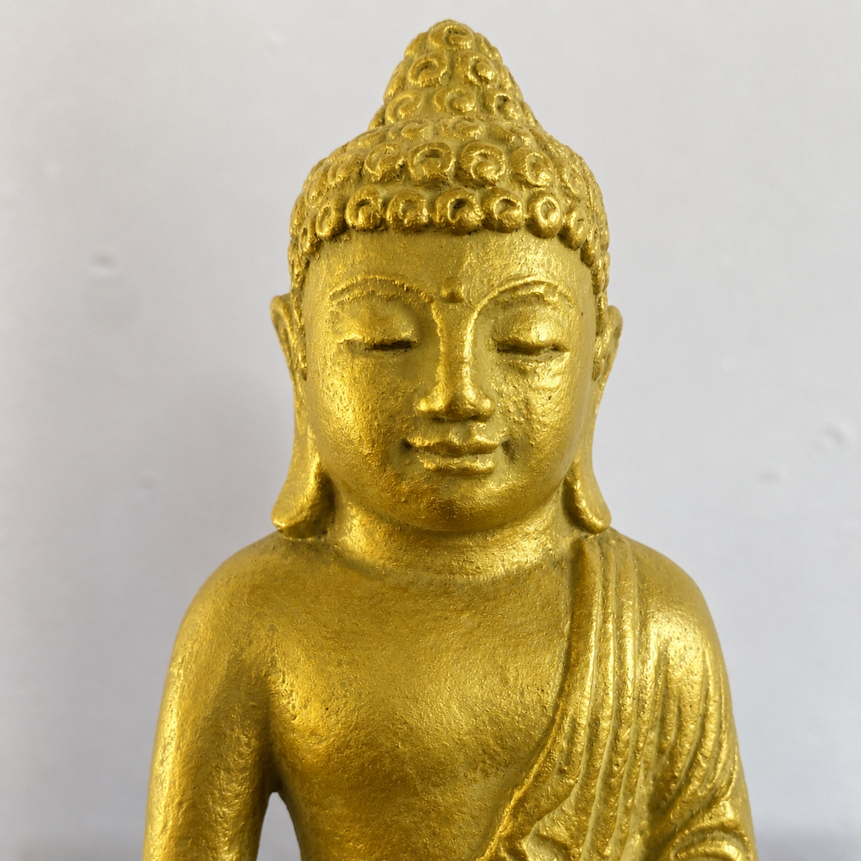 Detail image of a gold colored buddha.