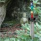 Chakra wind chime with a stone statue in a forest setting