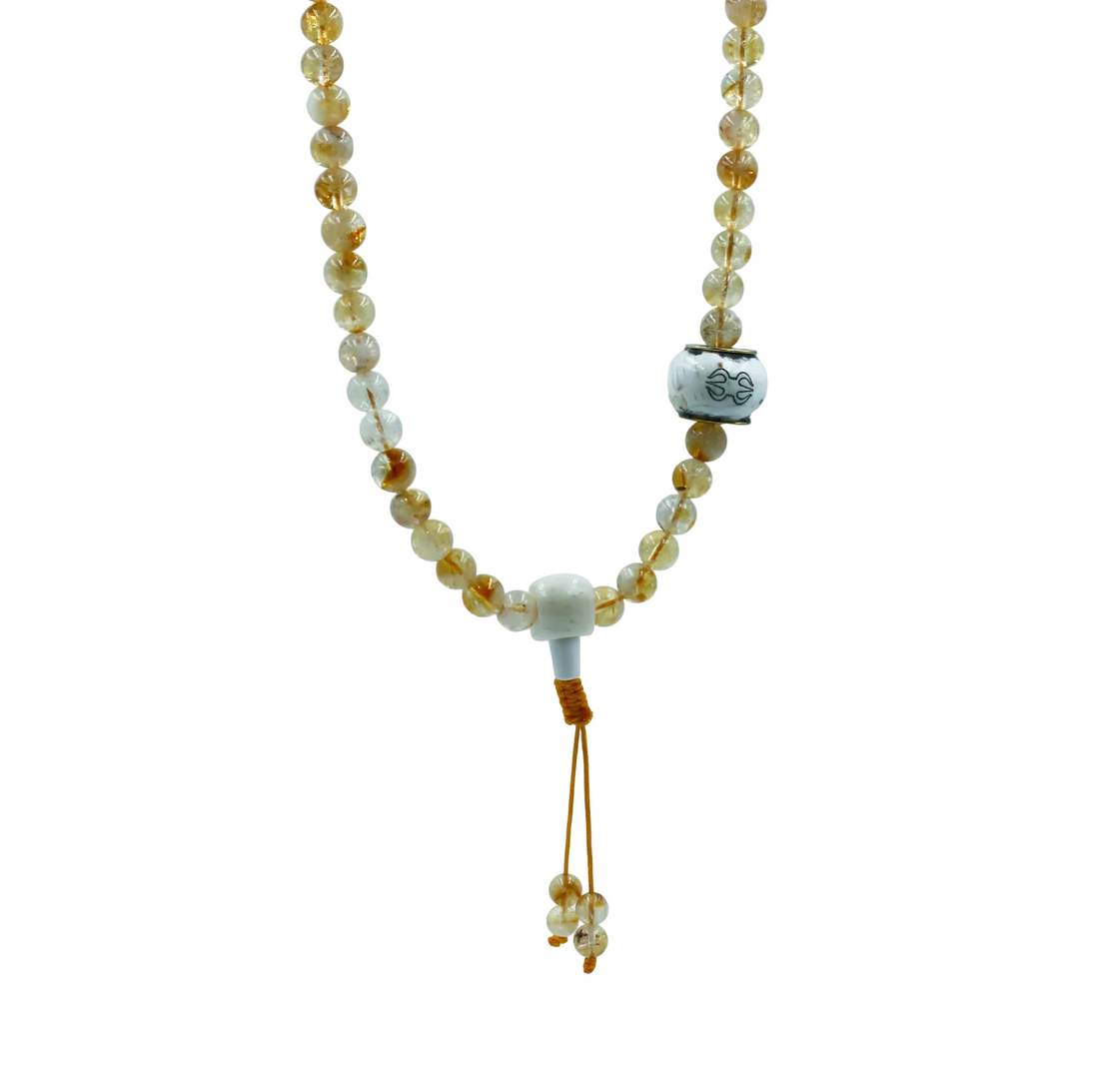 Mala with citrine stones and a tassel on a light gray background