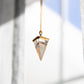 Crystal pendant hanging on a gold necklace.