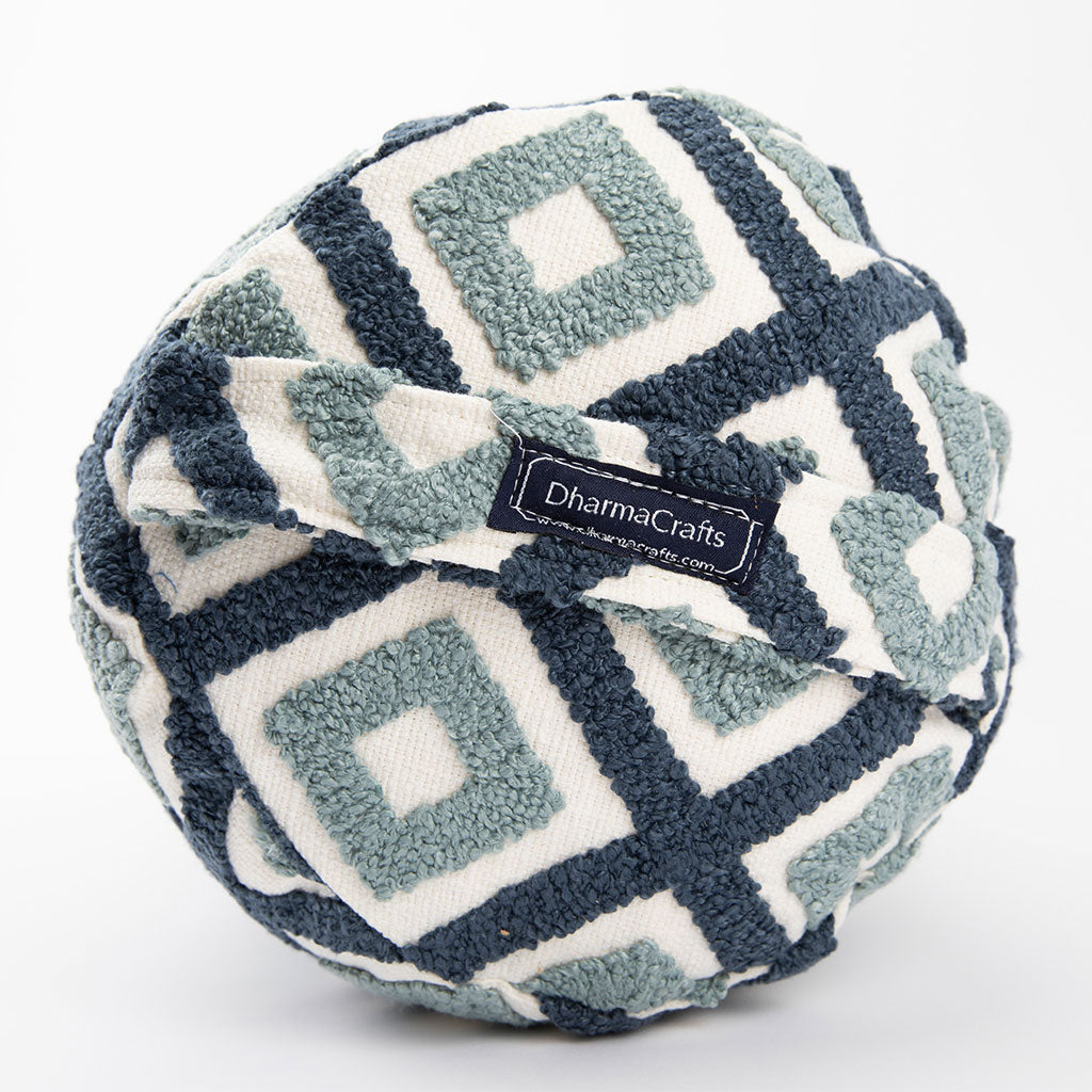 Fuzzy ball with geometric pattern and DharmaCrafts label on a white background