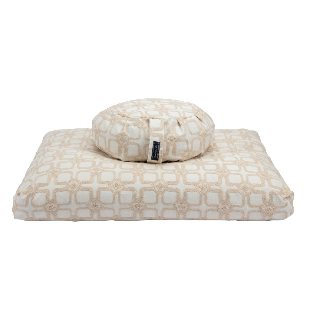 Beige and white patterned pet bed with a matching pillow on a white background