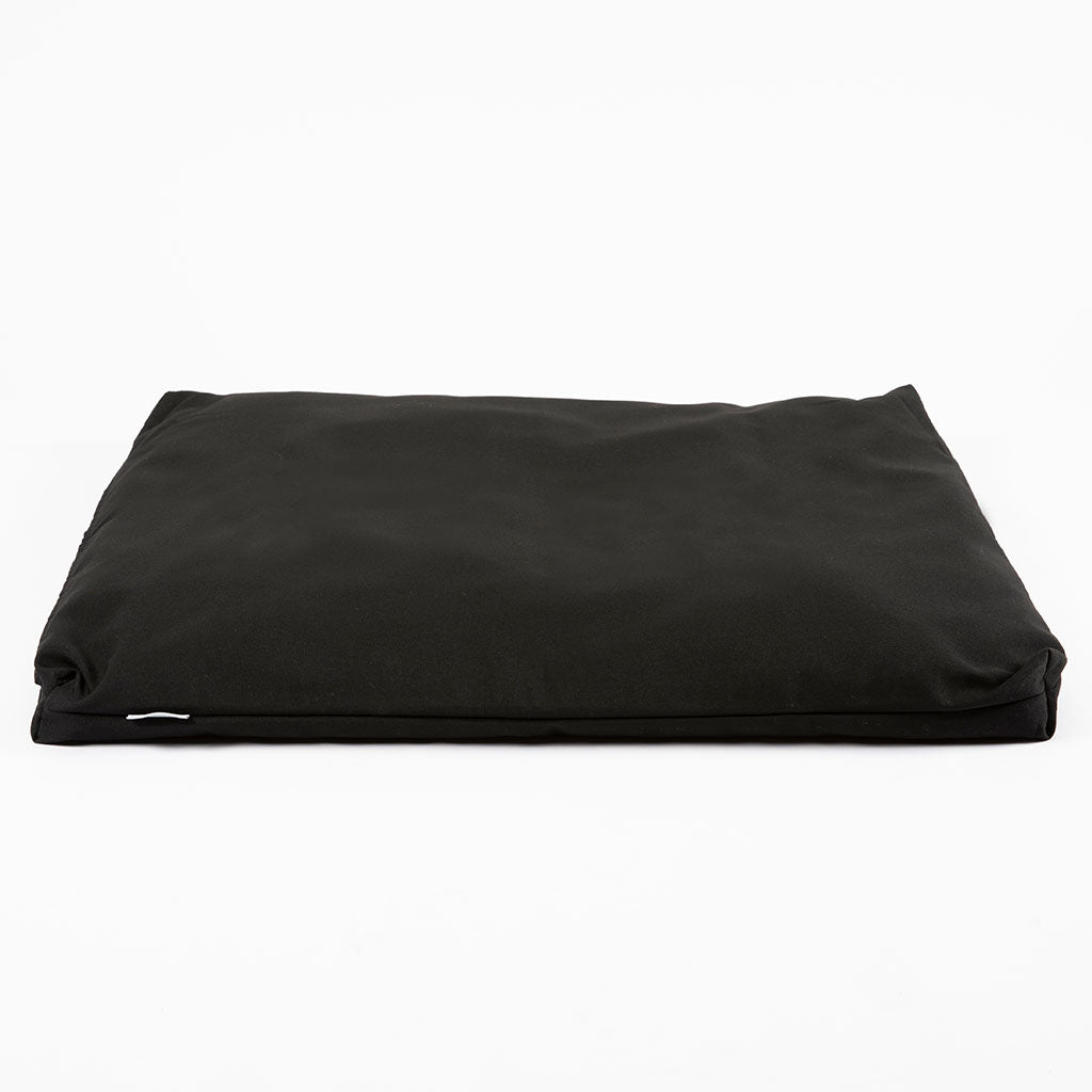 A black rectangular cushion or pet bed with a smooth fabric surface, photographed from a top-down angle on a clean white background.