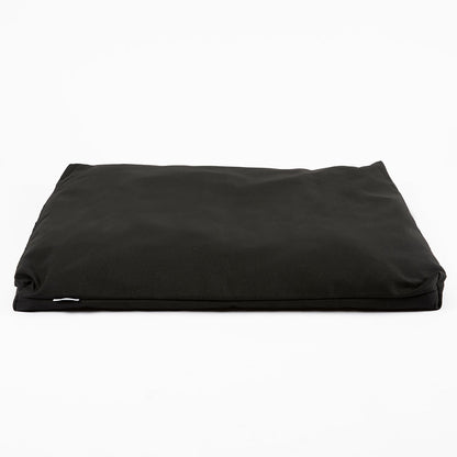 A black rectangular cushion or pet bed with a smooth fabric surface, photographed from a top-down angle on a clean white background.