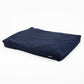 A navy blue rectangular cushion or floor pad with a smooth fabric surface, shown at an angle on a clean white background.