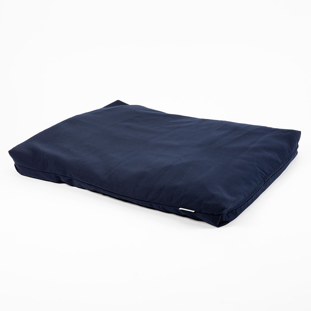 A navy blue rectangular cushion or floor pad with a smooth fabric surface, shown at an angle on a clean white background.