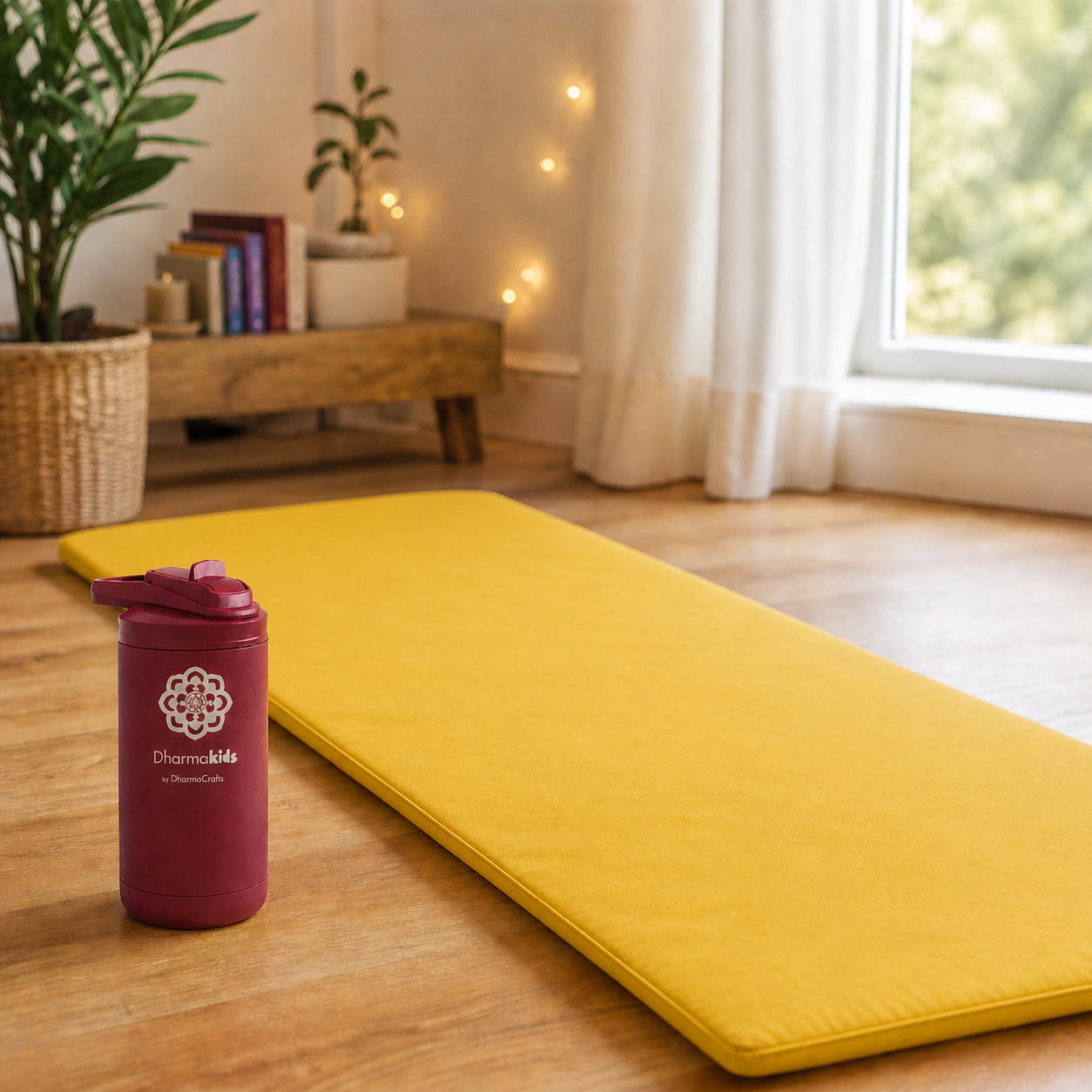 Red insulated water bottle on floor next to a yellow nap yoga mat. 