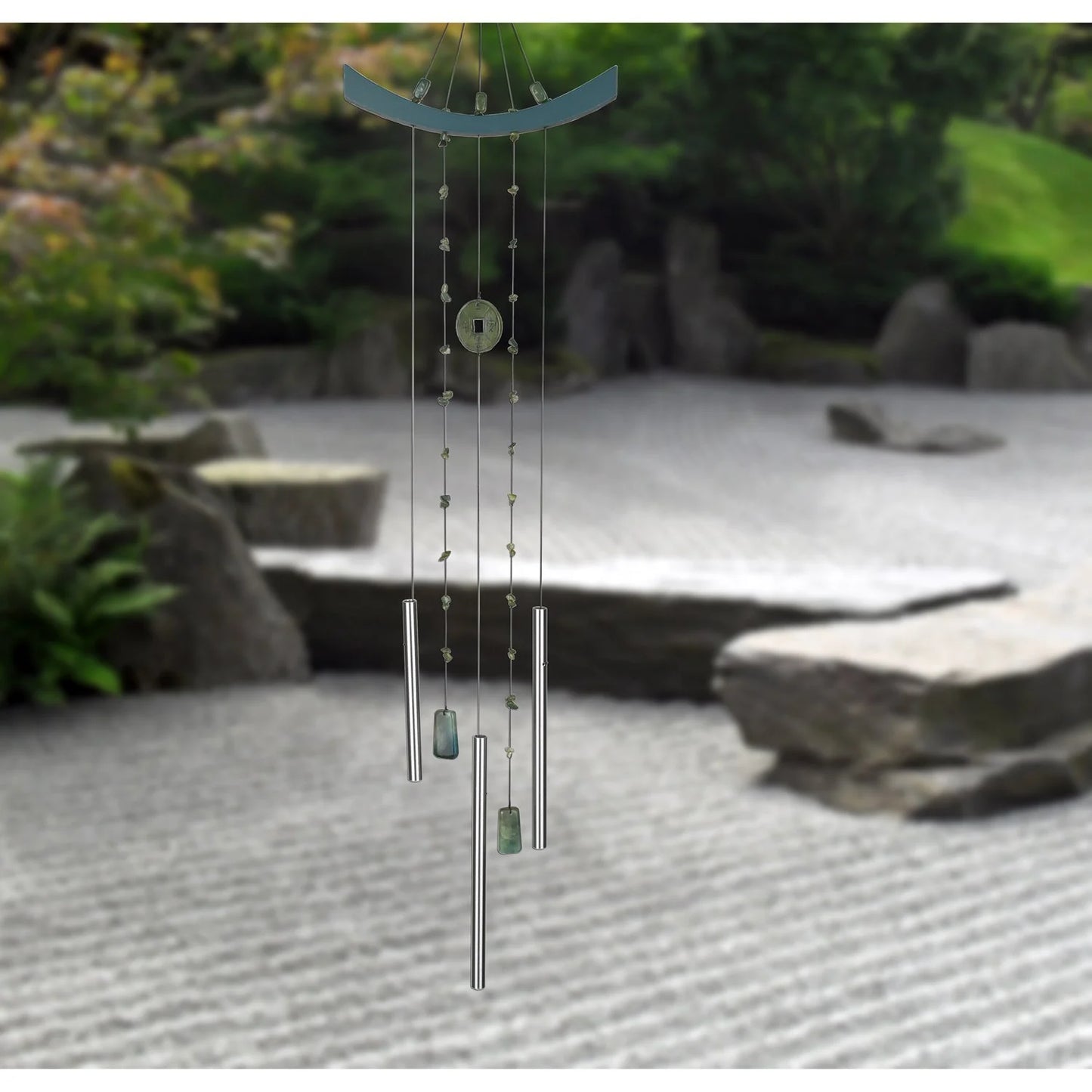 Decorative wind chime with stones on a garden background