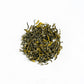 Dry green tea leaves on a white background