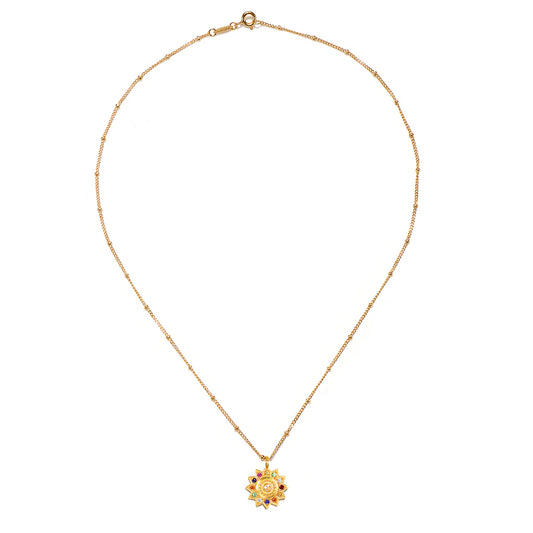 Gold necklace with a sun pendant on a white background.