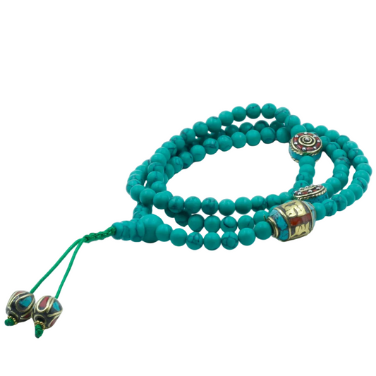 Turquoise mala beaded bracelet with decorative elements on a white background