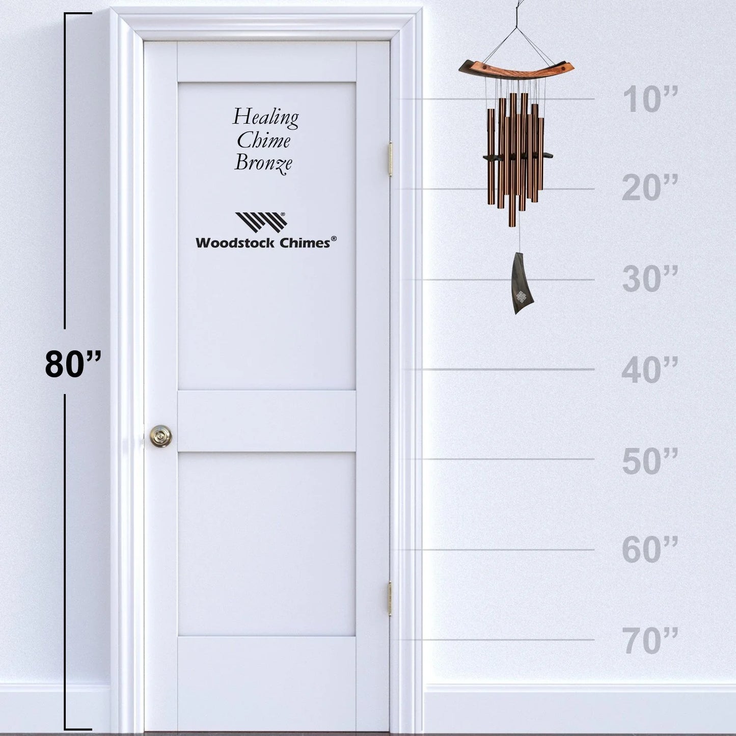 Woodstock Chimes wind chime next to a white door with height measurement scale.