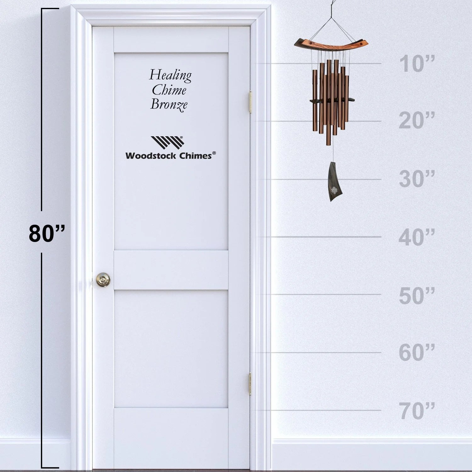 Woodstock Chimes wind chime next to a white door with height measurement scale.