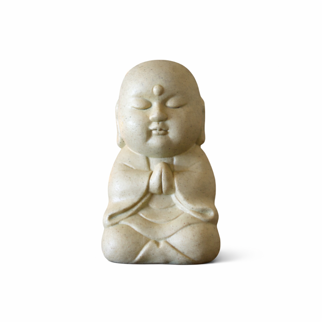 White stone sculpture of a seated figure on a white background