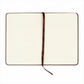 An open lined notebook with cream-colored pages, a dark brown cover edge, and a matching dark brown ribbon bookmark, shown on a plain white background.