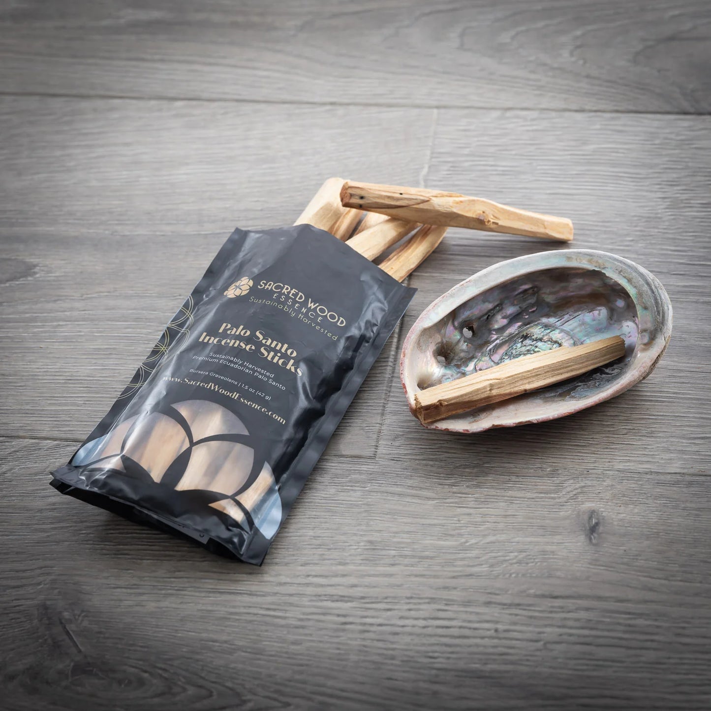 Package of Sacred Wood Palo Santo Incense Sticks on a wooden surface with incense sticks.