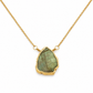 A gold chain necklace featuring a raw, irregular-shaped green labradorite stone pendant with a textured gold border, shown on a clean white background.