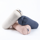 Three cylindrical bolster pillows in light beige, dusty pink, and slate blue, stacked together on a clean white background.