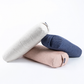 Three cylindrical yoga props or bolster pillows in light beige, dusty pink, and navy blue, stacked on a clean white background.