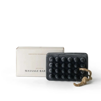 Charcoal massage soap bar with a box on a white background.
