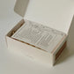Box with a sheet for mindful massage routine directions on a white background.