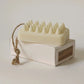 Massage soap bar resting on top of a box on a white background.
