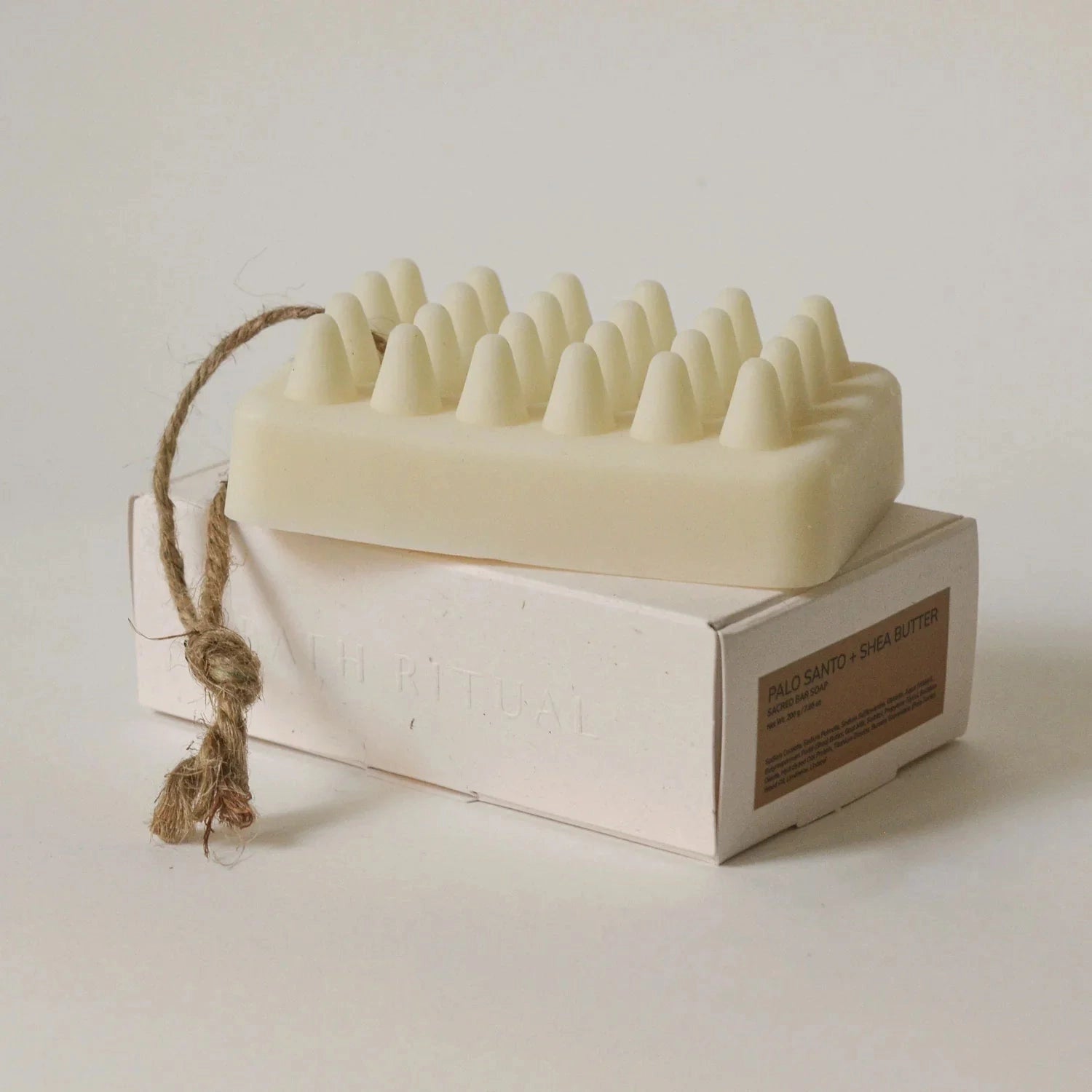 Massage soap bar resting on top of a box on a white background.