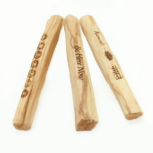Three wooden sticks with engraved text on a white background
