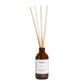 Reed diffuser with wooden sticks in a brown bottle on a light gray background