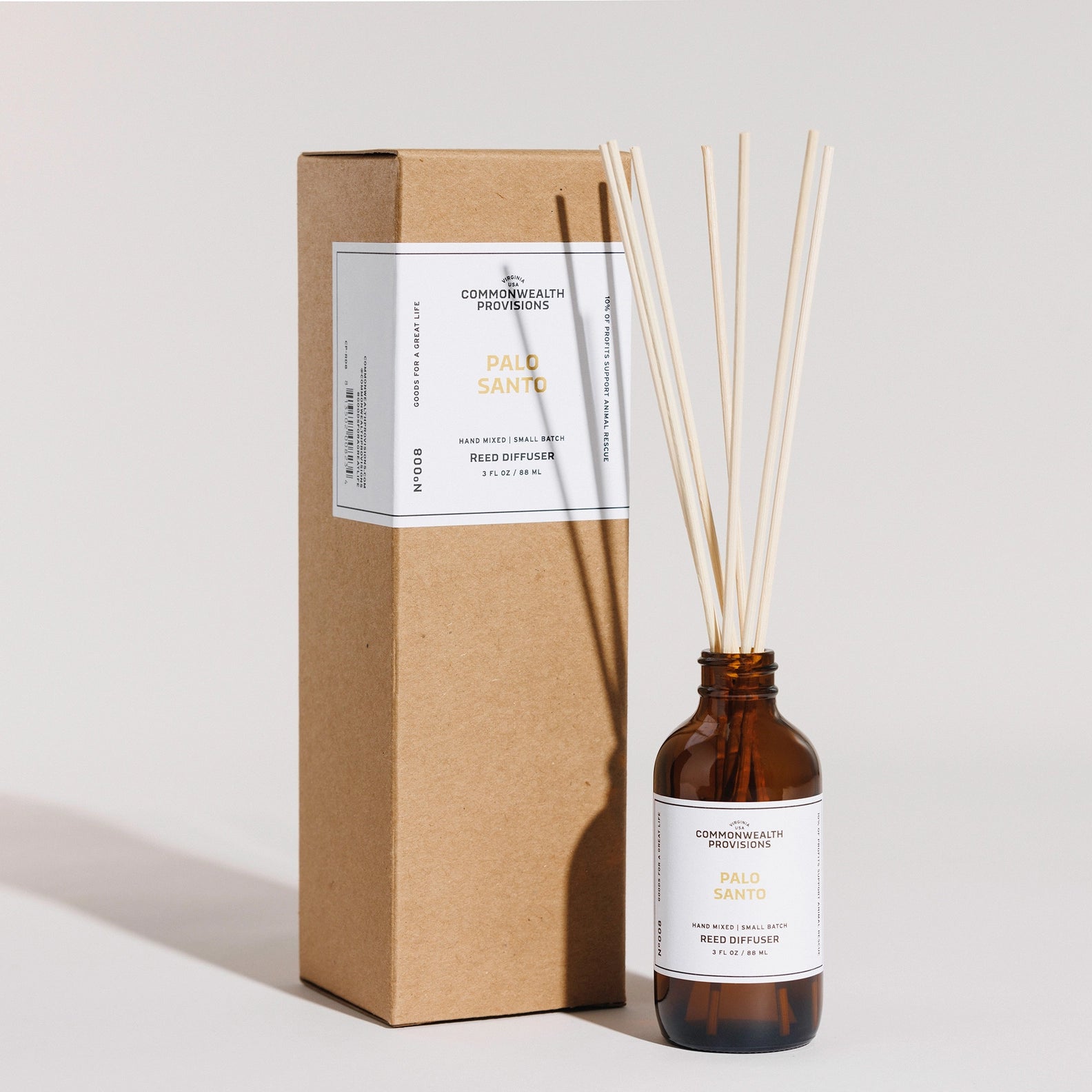 Reed diffuser with bottle and cardboard box on a light gray background
