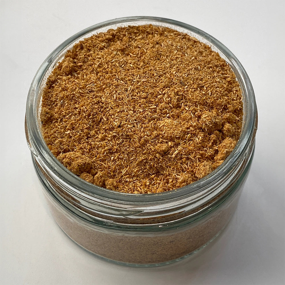 Glass jar filled with brown powder on a white background