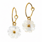 A pair of gold hoop earrings with dangling white daisy flower charms, shown against a plain white background.