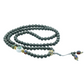 Gray beaded mala necklace with colorful accents on a white background