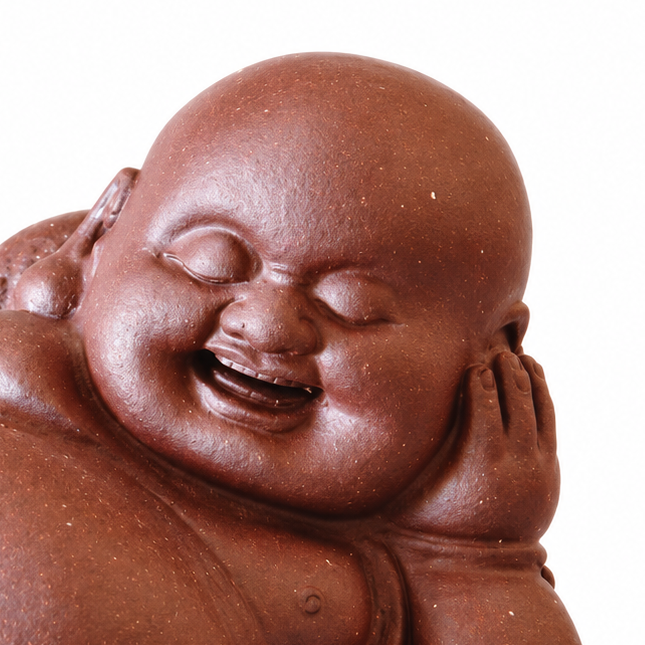 A smiling Buddha figurine in a reddish-brown terracotta color, shown on a plain white background.