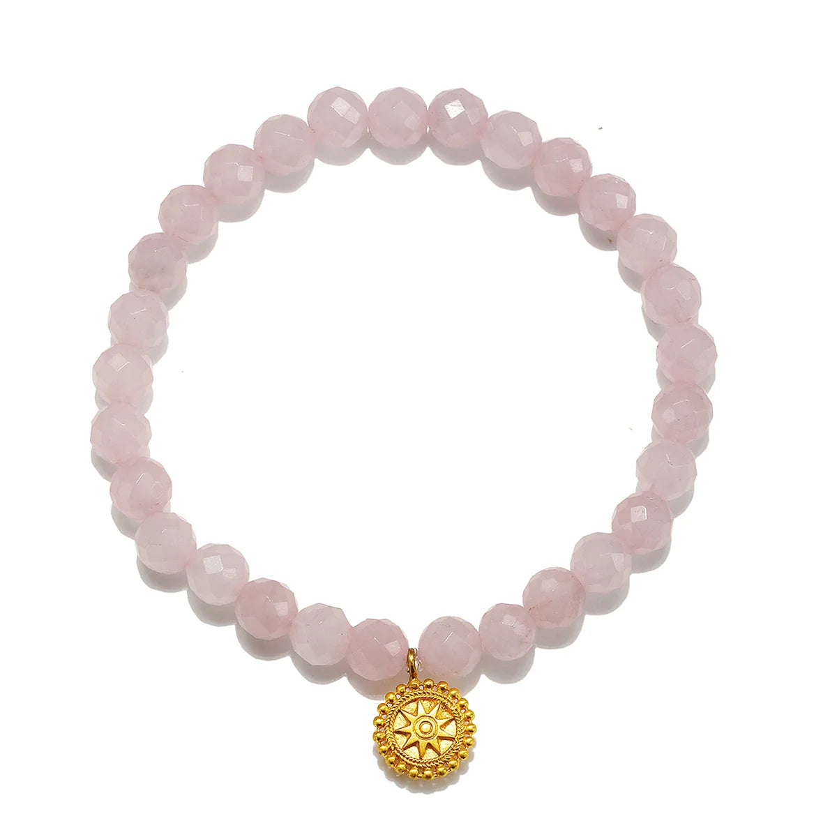 A pink faceted gemstone beaded bracelet with a gold-toned circular sunburst charm, displayed on a clean white background.