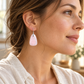 Woman's profile wearing rose quartz earrings.