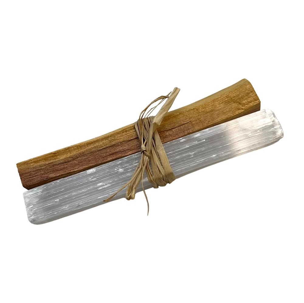 Palo santo and selenite tied together with twine on a white background.