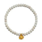 A beaded stretch bracelet made of round off-white stone beads with a small gold bee charm at the bottom center, shown on a plain white background.