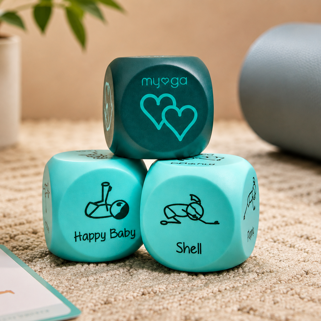 Three teal yoga dice stacked on a beige textured rug, with a yoga mat and a small card visible in a softly blurred indoor setting.