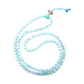 The Aquamarine Mala rests against a white backdrop and loosely coiled into a circle.