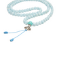 Close-up of the turquoise guru bead, silver accent bead, and knot on the Aquamarine Mala. It rests against a solid white backdrop.