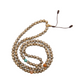 Hand Carved Shell Mala rests against a white backdrop and loosely coiled into a circle.