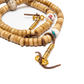 Close-up of the vajra counter charms and shell marker beads of Yak Bone Disc-Shaped Mala against a solid white backdrop.