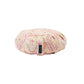 A round meditation cushion with a geometric pattern in shades of pink, green, and beige.